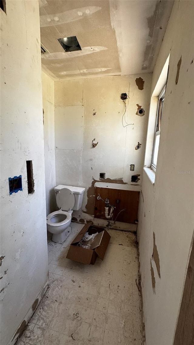 half bath featuring tile patterned floors and toilet