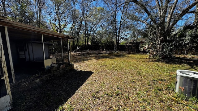 view of yard featuring central air condition unit, a fenced backyard, and a sunroom