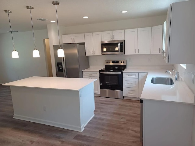 kitchen featuring white cabinets, stainless steel appliances, a kitchen island, and dark hardwood / wood-style floors