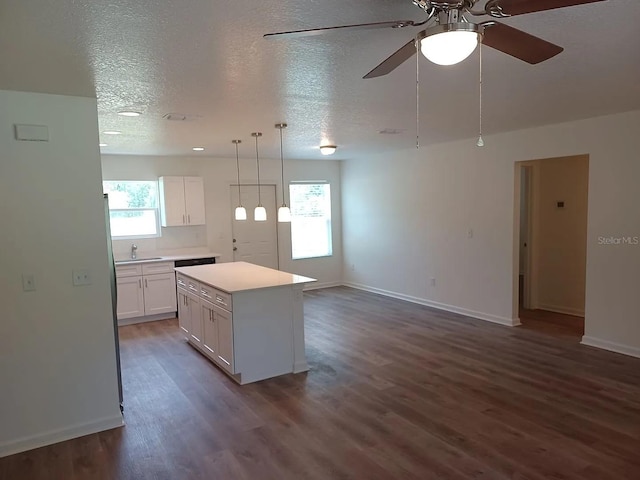 kitchen featuring white cabinetry, a kitchen island, a healthy amount of sunlight, and decorative light fixtures