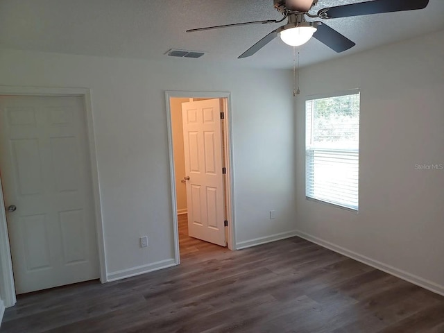 unfurnished bedroom with dark hardwood / wood-style flooring and ceiling fan