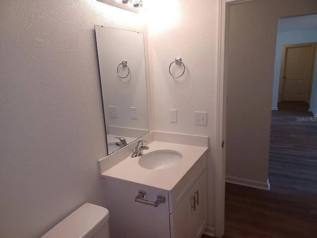 bathroom featuring hardwood / wood-style floors, vanity, and toilet