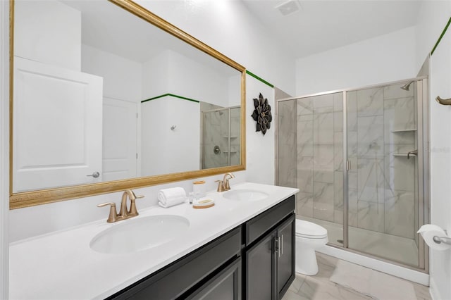 bathroom featuring toilet, vanity, and a shower with door