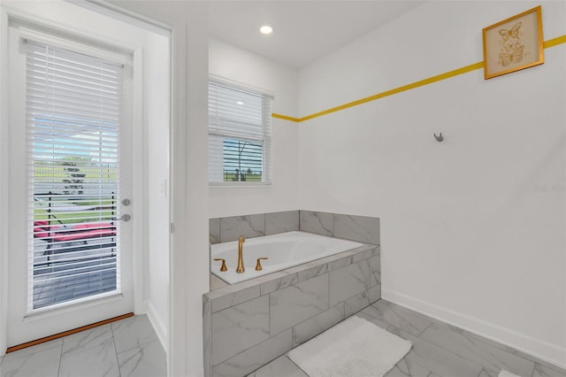 bathroom with tiled bath and a wealth of natural light