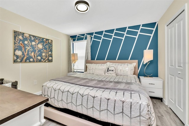 bedroom with a closet and light hardwood / wood-style flooring