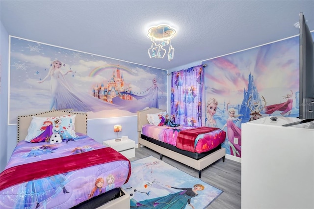 bedroom with a textured ceiling and hardwood / wood-style flooring