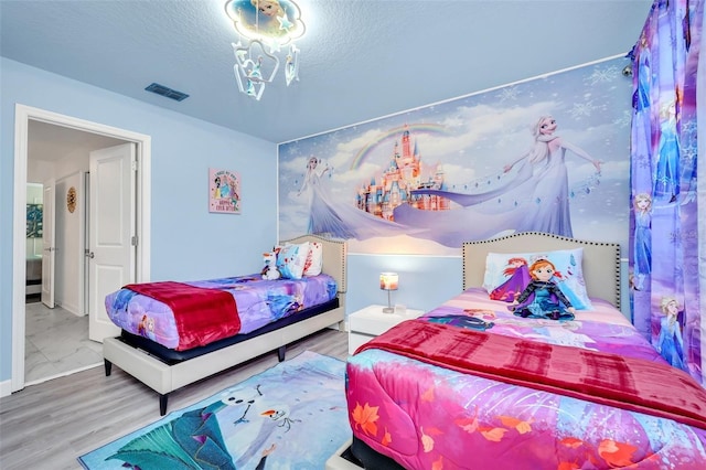 bedroom featuring hardwood / wood-style flooring and a textured ceiling