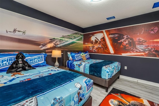 bedroom with a textured ceiling and hardwood / wood-style flooring