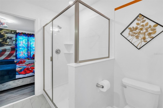 bathroom with a shower with shower door and toilet