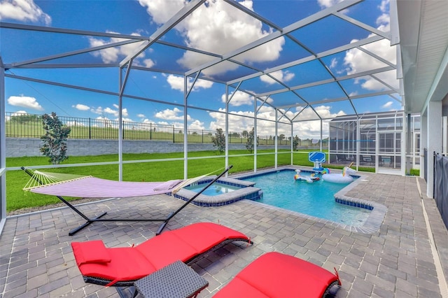 view of pool featuring glass enclosure, an in ground hot tub, a yard, and a patio