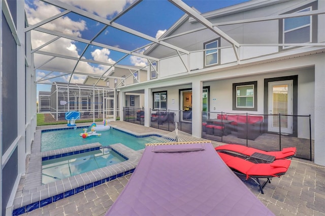 view of pool with a patio, glass enclosure, and an in ground hot tub