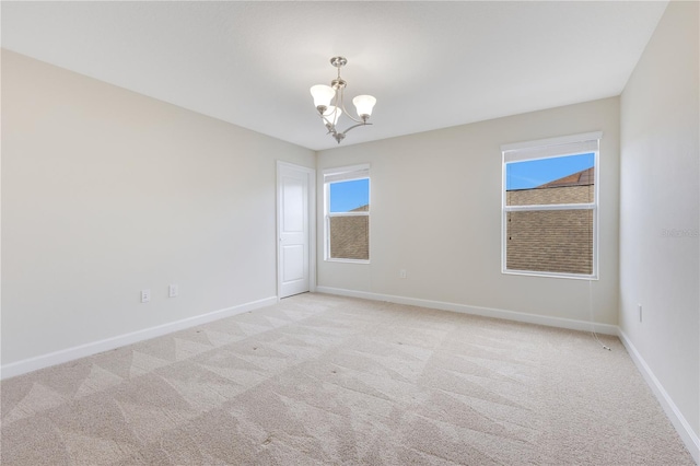 unfurnished room with light carpet and a notable chandelier