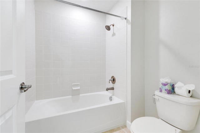 bathroom with toilet and tiled shower / bath