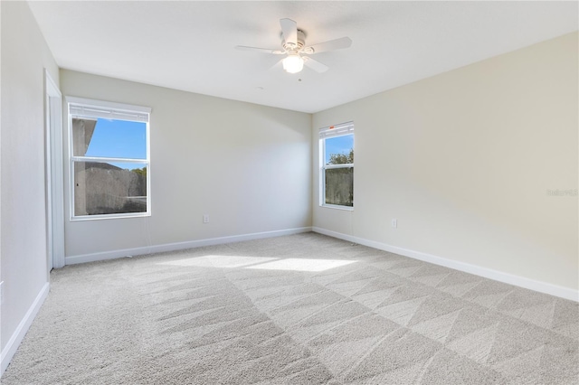 spare room featuring ceiling fan and light carpet