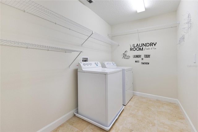 clothes washing area featuring washer and clothes dryer and a textured ceiling