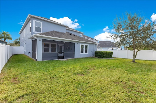 rear view of property with a sunroom and a yard