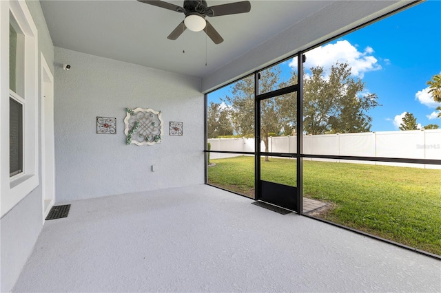 unfurnished sunroom with ceiling fan