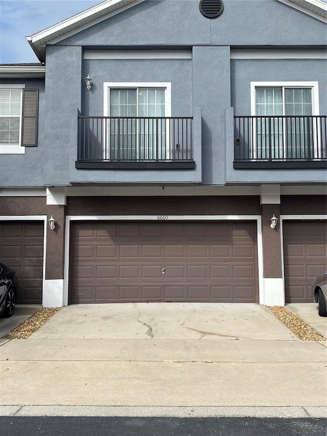 view of front facade with a balcony and a garage