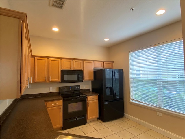 kitchen featuring a wealth of natural light, light tile patterned floors, and black appliances