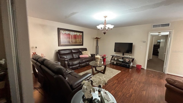 living room featuring dark hardwood / wood-style flooring and an inviting chandelier