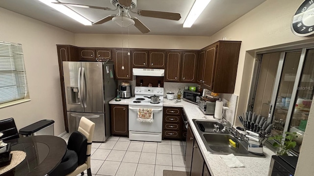 kitchen featuring dark brown cabinetry, appliances with stainless steel finishes, sink, ceiling fan, and light tile patterned floors