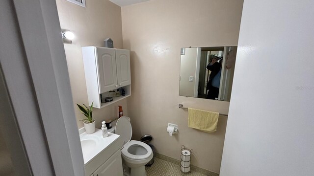 bathroom featuring toilet, vanity, and tile patterned flooring