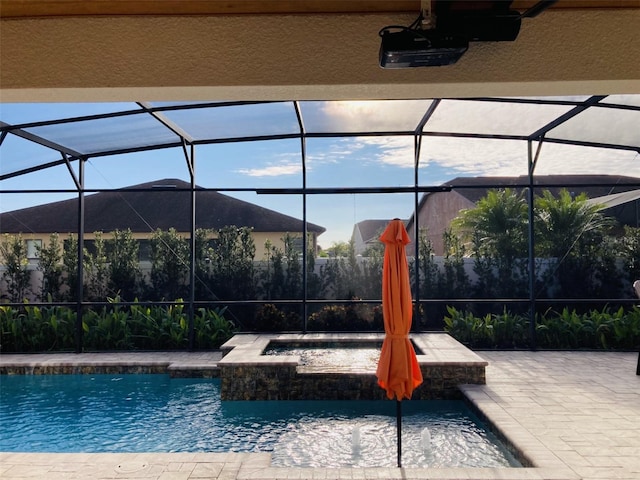 view of pool with glass enclosure, a patio, and a pool with connected hot tub