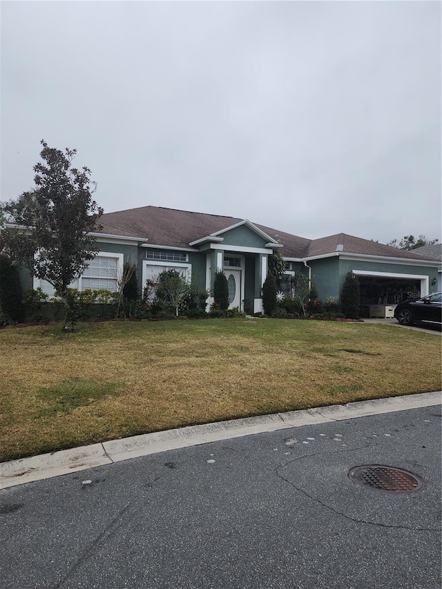 single story home with a garage and a front yard