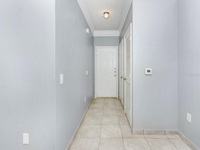 hallway with light tile patterned floors and crown molding