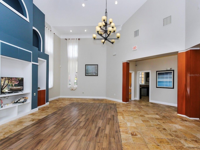 unfurnished living room featuring a high ceiling and an inviting chandelier