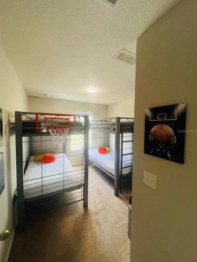 bedroom with a textured ceiling and carpet floors