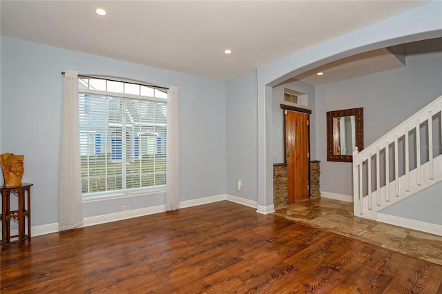 empty room with plenty of natural light and dark wood-type flooring