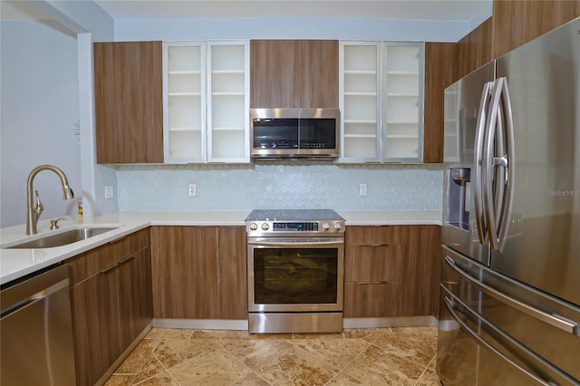 kitchen with appliances with stainless steel finishes, backsplash, and sink