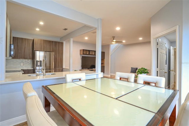 dining space with ceiling fan and sink