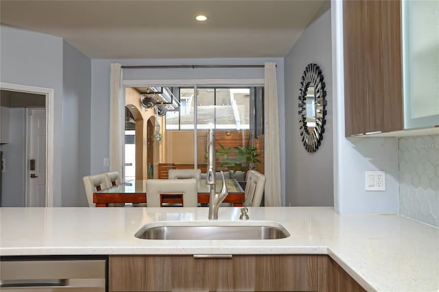 kitchen with light stone counters and sink