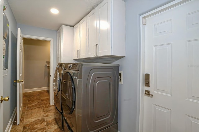 laundry area with washing machine and dryer and cabinets