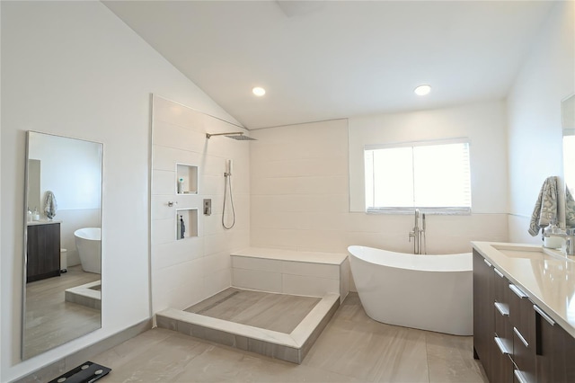 bathroom with plus walk in shower, vanity, and lofted ceiling