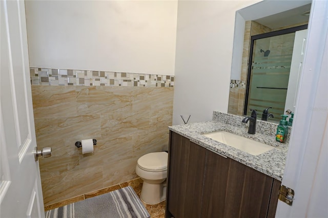 bathroom with vanity, tile patterned floors, toilet, tile walls, and walk in shower