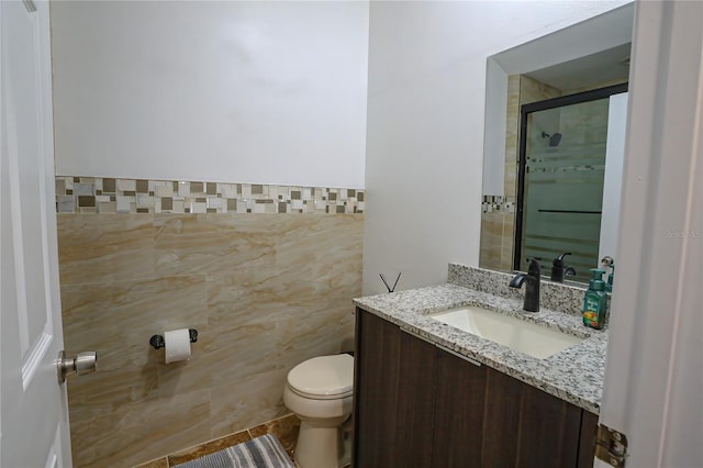 bathroom featuring vanity, tile patterned flooring, toilet, tile walls, and an enclosed shower