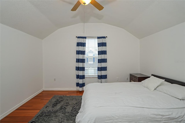 bedroom with a textured ceiling, dark hardwood / wood-style flooring, ceiling fan, and lofted ceiling