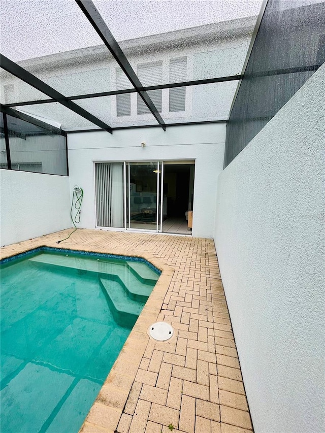 view of swimming pool featuring a lanai