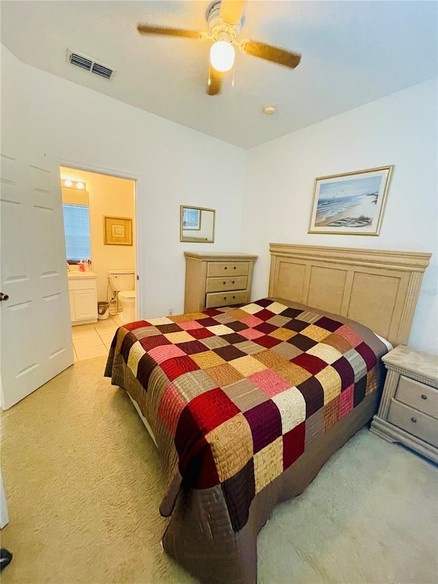 carpeted bedroom with ceiling fan and ensuite bathroom