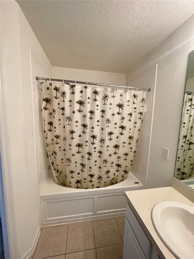 bathroom with vanity, tile patterned flooring, shower / bath combo with shower curtain, and a textured ceiling