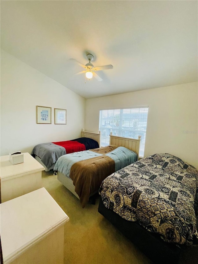 carpeted bedroom with ceiling fan and vaulted ceiling