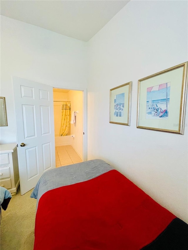 bedroom featuring light carpet and connected bathroom