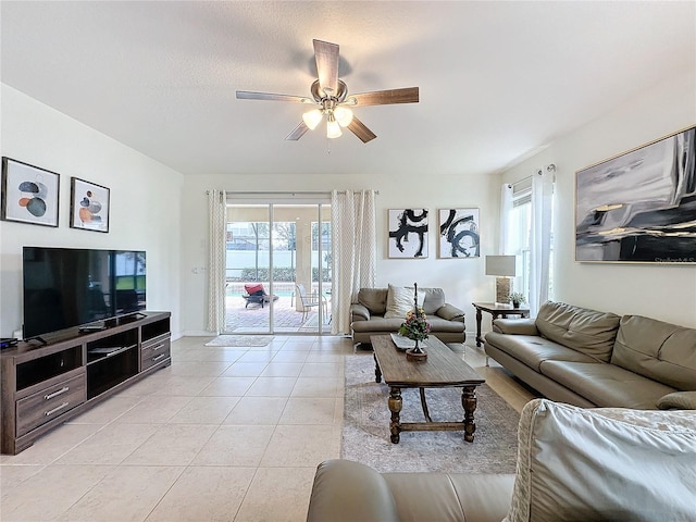 tiled living room with ceiling fan, a textured ceiling, and a healthy amount of sunlight