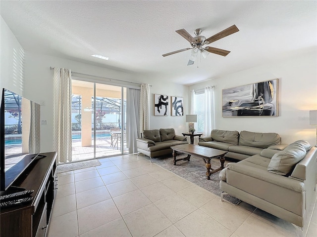 tiled living room with ceiling fan and a textured ceiling