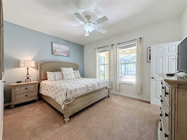 carpeted bedroom with ceiling fan and a textured ceiling