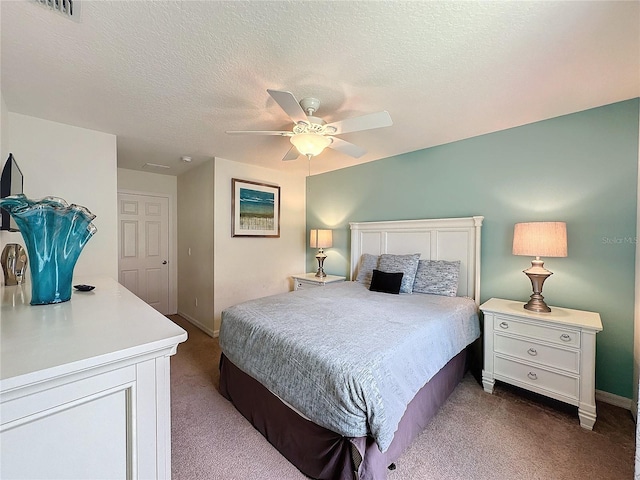 carpeted bedroom featuring a textured ceiling and ceiling fan