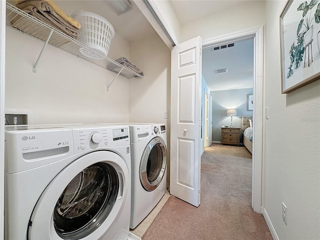 clothes washing area featuring light carpet and washing machine and dryer